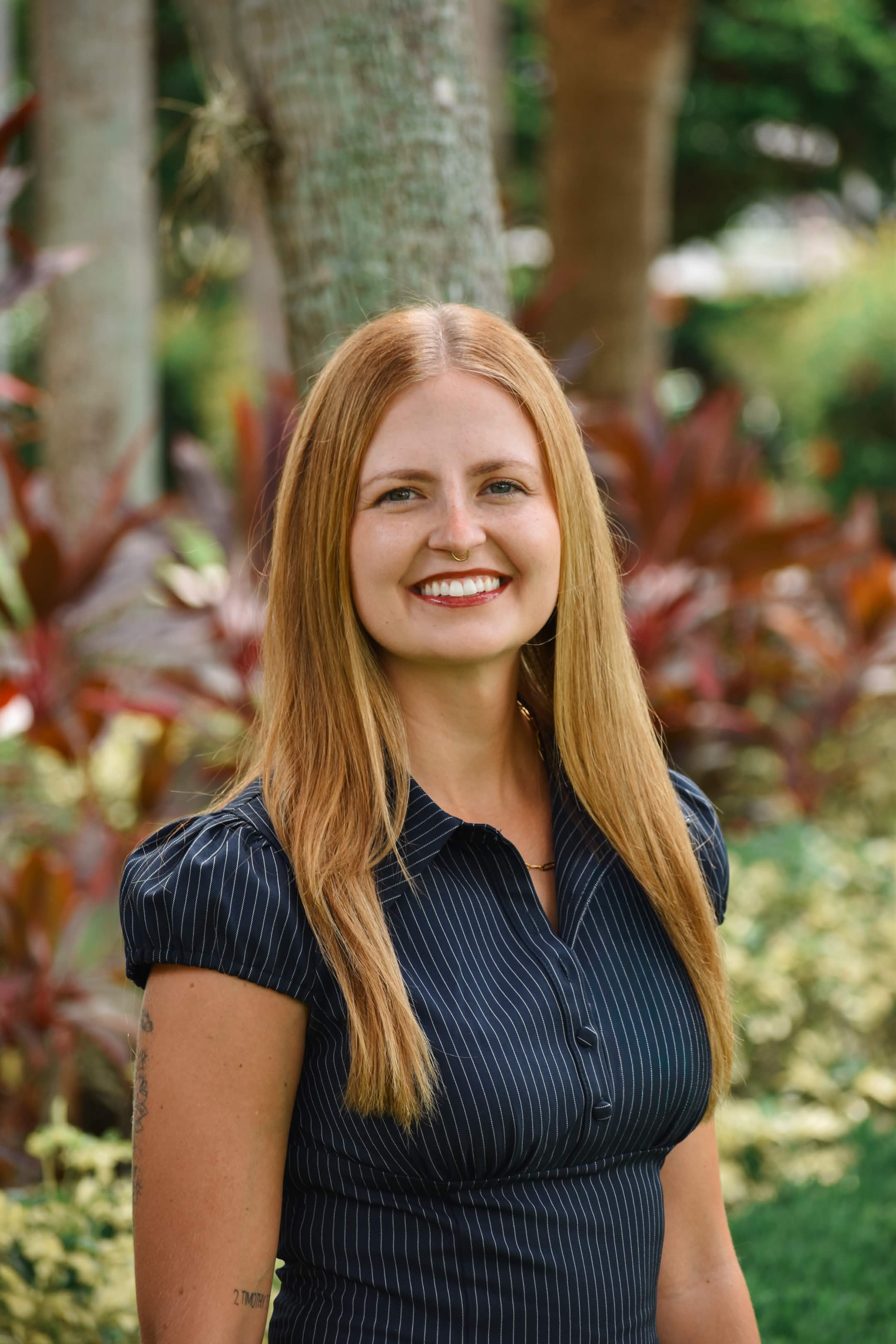 Danika Martinez smiling outdoors in a navy pinstripe blouse